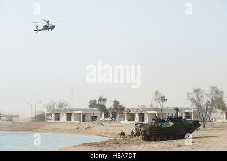 Un hélicoptère en vol stationnaire tandis que Qatar Marines des États-Unis à partir de la compagnie Kilo Battalion Landing Team 3e Bataillon, 6e Régiment de Marines, 24e Marine Expeditionary Unit, sortie d'un véhicule d'assaut amphibie de la Marine américaine pendant une simulation de débarquement amphibie sur l'île de Failaka, le 25 mars 2015, au cours de l'exercice 2015 Eagle résoudre. L'exercice permet aux 29 pays partenaires l'occasion d'aborder les problèmes régionaux liés à l'asymétrie/guerre non traditionnelle dans un environnement multi-national. C'est le gouvernement de la première fois Eagle hébergement résoudre ; qui est la premiere Péninsule Arabique et du Golfe Banque D'Images