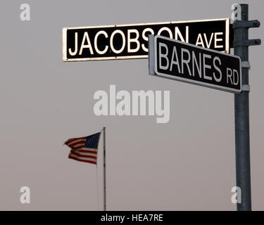 Le drapeau américain fièrement les vagues dans l'arrière-plan derrière la nouvelle route Barnes et Jacobson intersection Avenue signe sur une base aérienne dans la région du golfe Persique le 10 juin. L'intersection est nommé en l'honneur d'un membre de la 1re classe Eric Barnes, qui est mort le 10 juin 2007 à la suite d'un dispositif explosif attaque d'un convoi de l'Armée de l'air à environ 100 milles au sud de Bagdad, l'Iraq, et d'un membre de la 1re classe Elizabeth Jacobson, décédé le 28 septembre 2005 lors d'un convoi près de Camp Bucca, Iraq, lorsque son véhicule a été touché par un IED. Elle est la première femme aviateur tué dans l'exercice de ses fonctions dans l'opération Iraqi Freedom. Banque D'Images