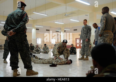 Des soldats de la Shurta iraquien, Département de la police des frontières, effectuer des recherches sur le personnel les uns les autres comme des soldats américains et dirigeants iraquiens montre lors de la fouille corporelle, la classe à Bassora, Irak, 2 septembre. Les soldats du 1er Bataillon Commando, bataillon de l'Équipe de transition, enseigner les cours d'inculquer la confiance en soi dans l'auto-défense, lecture de carte, le système de positionnement global, de premiers soins et le personnel de recherche. Banque D'Images