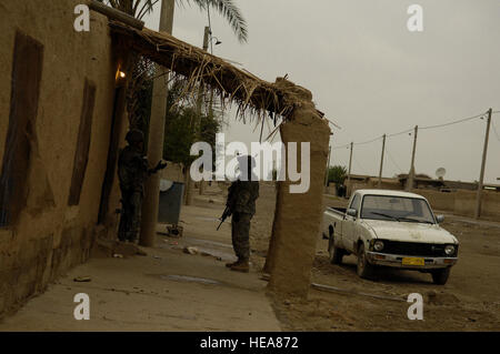 Les soldats de l'armée américaine d'assurer la sécurité en tant que policiers iraquiens recherchez une maison pour les éléments d'intérêt au cours d'une mission de police irakienne par l'Unité des services d'urgence le 1er avril. Les soldats sont affectés à la Compagnie Alpha, 2e Bataillon, 25e Division d'infanterie, Schofield Barracks, à Hawaï. Le sergent-chef. Andy Dunaway) Banque D'Images