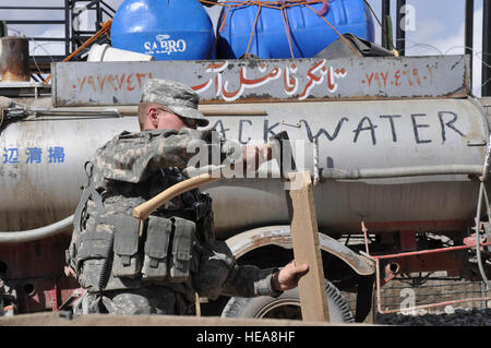 La province de Paktia, Afghanistan - l'armée américaine de la CPS. Michael Spires, de la Compagnie de la Police militaire de la 410th hors de Fort Hood, au Texas, les côtelettes bois de rebut pour sa garde shack cuisinière pour garder au chaud pendant que son poste permanent à base d'éclairs dans le district de Gardez de la province de Paktia, en Afghanistan, le 4 mars. U.S. Air Force capitaine principal Sgt. Jessica D'Aurizio, 203e Corps canadien, Affaires publiques de l'Armée nationale afghane Advisory Team) Banque D'Images