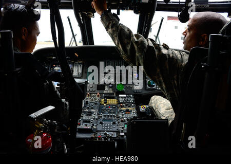 L'Adjudant-chef de l'armée américaine 4 Ronald Rodgers, 1-228ème bataillon du régiment de l'Aviation l'agent de sécurité, démontrent la bonne procédure à l'arrêt d'un UH-60 Black Hawk pour le sergent de l'US Air Force. Steven Saulo, 612e Escadron de la base de l'air, pompier à la base aérienne de Soto Cano, le Honduras, le 15 janvier 2015. Au moins une fois par trimestre, la 612e équipe avec ABS le 1-228e Avn. Regt. d'examiner la formation de sauvetage d'écrasement d'aéronef et de procédures d'urgence pour le UH-60 Black Hawk. Tech. Le Sgt. Heather Redman) Banque D'Images