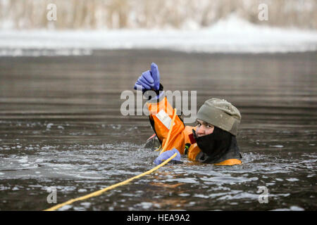 Jacob Davidson Senior Airman, un pompier de Cleveland (Ohio), affecté à la 673e Escadron de génie civil, les signaux qu'il a un contrôle positif de throw bag tout en participant à l'eau froide et au sauvetage sur glace Joint Base Elmendorf-Richardson, Alaska, le 20 Déc., 2015. La formation des pompiers JBER enseigne l'auto-sauvetage et les techniques de récupération de la victime, et certifié en tant que techniciens de sauvetage sur glace. Alejandro Pena) Banque D'Images