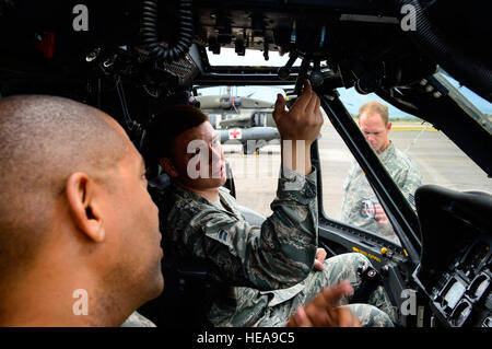 U.S. Air Force Divine Andrew Navigant de première classe, 612e Escadron de la Base Aérienne de pompier, examine les procédures d'arrêt d'un UH-60 Black Hawk de l'armée américaine avec l'Adjudant-chef 4 Ronald Rodgers, 1-228ème bataillon du Régiment d'aviation, agent de sécurité à la base aérienne de Soto Cano, le Honduras, le 15 janvier 2015. Au moins une fois par trimestre, la 612e équipe avec ABS le 1-228e Avn. Regt. d'examiner la formation de sauvetage d'écrasement d'aéronef et de procédures d'urgence pour le UH-60 Black Hawk. Tech. Le Sgt. Heather Redman) Banque D'Images