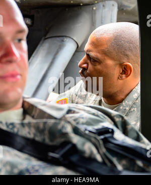 L'Adjudant-chef de l'armée américaine 4 Ronald Rodgers, 1-228ème bataillon du régiment de l'Aviation l'agent de sécurité, parle aux aviateurs de 612e Escadron de la Base Aérienne de pompiers sur les procédures de retrait d'un pilote blessé d'un UH-60 Black Hawk lors de la formation de sauvetage accident d'avion à la base aérienne de Soto Cano, le Honduras, le 15 janvier 2015. Au moins une fois par trimestre, la 612e équipe avec ABS le 1-228e Avn. Regt. d'examiner la formation de sauvetage d'écrasement d'aéronef et de procédures d'urgence pour le UH-60 Black Hawk. Tech. Le Sgt. Heather Redman) Banque D'Images