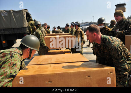 Les Marines américains de centre de formation interarmes, Japon, Fuji Camp et la masse des soldats de la Force d'autodéfense japonaise boîtes charge des dons de couvertures et de vêtements sur un camion le 29 mars 2011, à l'Aéroport de Sendai pendant l'opération Tomodachi de secours humanitaire. Le s.. Ali E. Flisek, U.S. Air Force Banque D'Images