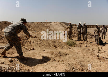 Le sergent de l'armée américaine. Billy maître de l'Administration centrale et de l'Administration centrale, l'entreprise K-9 1ère Stryker Brigade Combat Team, 25e Division d'infanterie, montre un policier iraquien comment inciter son chien pendant un exercice de formation mixte K-9 avec des policiers iraquiens du chien de police irakienne de Diyala programme sur base d'opérations avancée, cheval de guerre, près de Baqouba, l'Iraq, le 2 août. Banque D'Images