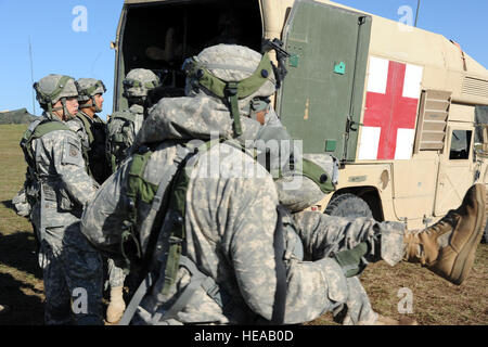 Les médecins de l'armée américaine transporter un soldat blessé d'une ambulance en compagnie Charlie Meds, champ base Geronimo, pendant une simulation d'attaque au sol, Joint Readiness Training Centre (JRTC), de Fort Polk, en Louisiane, le 18 octobre 2012. JRTC 13-01 éduque appelés à combattre les soins aux patients et l'évacuation aéromédicale dans un environnement de combat simulé. MSgt senior. Kim Allain Banque D'Images