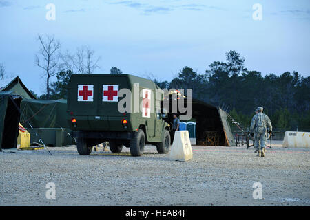 Les soldats de l'armée américaine avec le soutien de combat 328transport Hôpital aviateurs blessés sur une ambulance pour le triage après une simulation d'attaque de tir indirect sur la mise en scène d'évacuation aéromédicale Mobile Installation à Joint Readiness Training Center, Fort Polk, en Louisiane, le 23 février 2013. Les membres du service au JRTC 13-04 sont éduqués dans la lutte contre les soins aux patients et l'évacuation aéromédicale dans un environnement de combat simulé. Tech. Le Sgt. Francisco C. Govea II/ libéré) Banque D'Images