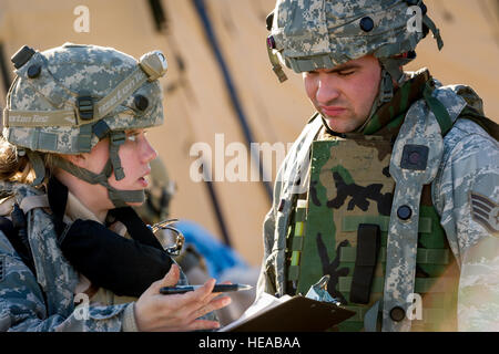 Le personnel de l'US Air Force Sgt. Kristin Thompson, de la gestion des services de santé artisan, 375e Groupe médical, Scott Air Force Base, dans l'Illinois, et Zachary Parker, spécialiste de la transmission radio fréquence, 43e Escadron d'évacuation aéromédicale, Pape Army Airfield, N.C., discuter des rapports de situation à Joint Readiness Training Center, Fort Polk (JRTC), en Louisiane, le 17 janvier 2014. Les membres du service au JRTC 14-03 sont éduqués dans la lutte contre les soins aux patients et l'évacuation aéromédicale dans un environnement de combat simulé. Le sergent-chef. John R. Nimmo, Soeur/) Banque D'Images