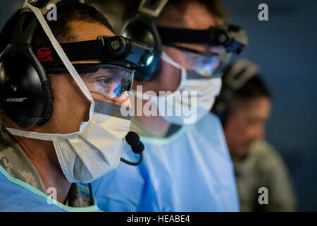 De gauche, tactical critical care - amélioration de l'équipe expéditionnaire (TCCET-E) les membres de l'équipe, le sergent-chef de l'US Air Force. Jose, Arias-Patino chirurgie opératoire Technicien, et le lieutenant-colonel de l'US Air Force Gerald Fortuna, chirurgien traumatologie, tant avec le 86e Groupe médical, Base aérienne de Ramstein, en Allemagne, effectuer une simulation de procédure chirurgicale laparotomie exploratoire tandis qu'en vol à bord d'un C-17 Globemaster III à Joint Readiness Training Centre (JRTC), de Fort Polk, en Louisiane, le 17 janvier 2014. Les membres du service au JRTC 14-03 sont éduqués dans la lutte contre les soins aux patients et l'évacuation aéromédicale dans un environnement de combat simulé Banque D'Images