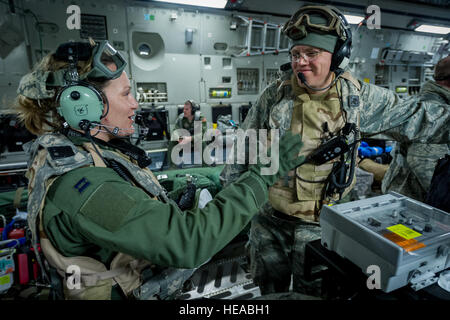 Le capitaine de l'US Air Force Danielle Cooper, infirmière de vol, 43e Escadron d'évacuation aéromédicale, Pape Army Airfield, N.C., des entretiens avec des membres de l'équipe transport soins critiques U.S. Air Force, le Lieutenant-colonel Alan Guhlke infirmier anesthésiste, 711e aile de la performance humaine, Wright-Patterson Air Force Base, Ohio, tandis qu'à bord d'un C-17 Globemaster III à Joint Readiness Training Centre (JRTC), de Fort Polk, en Louisiane, le 18 janvier 2014. Les membres du service au JRTC 14-03 sont éduqués dans la lutte contre les soins aux patients et l'évacuation aéromédicale dans un environnement de combat simulé. Le sergent-chef. John R. Nimmo, Soeur/) Banque D'Images