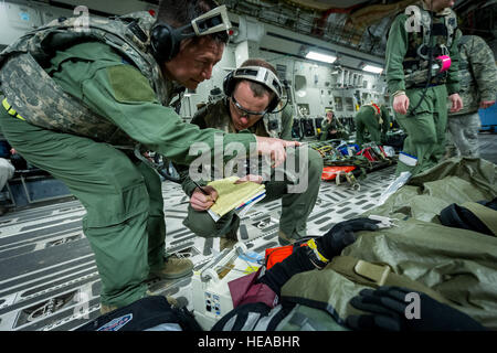 De gauche, tactical critical care - amélioration de l'équipe expéditionnaire (TCCET-E) membre de l'US Air Force, le Capitaine Richard Rogers, infirmière anesthésiste, 86e Groupe médical, Base aérienne de Ramstein, en Allemagne, et le major de l'US Air Force Corey Norton, infirmière de vol, 43e Escadron d'évacuation aéromédicale, Pape Army Airfield, N.C., l'enregistrement des signes vitaux du patient alors qu'en vol à bord d'un C-17 Globemaster III à Joint Readiness Training Centre (JRTC), de Fort Polk, en Louisiane, le 18 janvier 2014. Les membres du service au JRTC 14-03 sont éduqués dans la lutte contre les soins aux patients et l'évacuation aéromédicale dans un environnement de combat simulé. Le sergent-chef. John R. Ni Banque D'Images