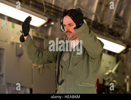 Le sergent de l'US Air Force. Corey Cochram, arrimeur, à partir du 6ème escadron de transport aérien, Joint Base McGuire-Dix-Lake Hurst, N.C., donne un signal pour un effet chariots tout terrain pour la sauvegarde à partir de la rampe d'un C-17 Globemaster III au cours d'un exercice sur le terrain au Joint Readiness Training Centre (JRTC), de Fort Polk, en Louisiane, le 14 mars 2014. Les membres du service au JRTC 14-05 sont éduqués dans la lutte contre les soins aux patients et l'évacuation aéromédicale dans un environnement de combat simulé. Le sergent-chef Joseph Araiza Banque D'Images