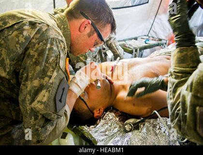 Le sergent de l'armée américaine. Zachary Doughty, medic, combat avec la Compagnie Charlie, 701e Bataillon de soutien de la Brigade, de Fort Riley, au Kansas, vérifie si il y a quelque chose de bloquer une simulation de patients de la gorge pendant un exercice sur le terrain au Joint Readiness Training Centre (JRTC), de Fort Polk, en Louisiane, le 15 mars 2014. Les membres du service au JRTC 14-05 sont éduqués dans la lutte contre les soins aux patients et l'évacuation aéromédicale dans un environnement de combat simulé. Le sergent-chef Joseph Araiza Banque D'Images