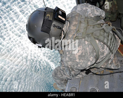 Le sergent de l'armée américaine. Kyle Farnes, chef d'équipe affecté à Joint Task Force-Bravo 1-228ème régiment d'aviation, exploite le palan d'un UH-60 Black Hawk sur l'océan Atlantique au large de la côte du Honduras lors d'un palan au-dessus de l'eau d'entraînement, le 18 novembre 2013. Le treuil est utilisé pour abaisser un medic vol afin d'atteindre les victimes lors des opérations de sauvetage et de l'evasan. L'exercice a fait partie d'un collectif d'une semaine d'entraînement (CTE) menée par le 1-228e. Le capitaine Zach Anderson) Banque D'Images