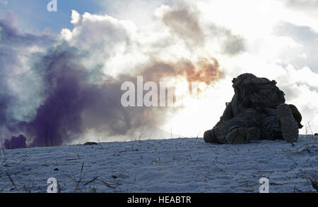 Un parachutiste affecté à la 3e Bataillon, 509e Parachute Infantry Regiment d'infanterie, 4e Brigade Combat Team (Airborne) 25e Division d'infanterie de l'armée américaine en Alaska, manoeuvres au sommet de la colline couverte de neige pourpre comme la fumée s'élève de l'avant lors d'un live-le-feu et mouvement-à-contact de la paix sur la bataille d'infanterie au cours Joint Base Elmendorf-Richardson, Alaska, le Mardi, Novembre 8, 2016. Les soldats de l'infanterie de base axés sur des compétences telles que le mouvement de l'équipe d'incendie, de la communication, le passage d'incendie, et une fois sur l'objectif l'identification et l'élimination des caches d'armes et le traitement et l'évacuation des blessés. Un Banque D'Images