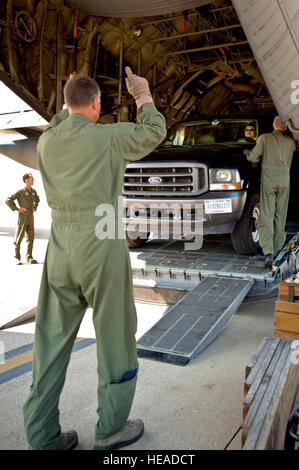 Le conseiller-maître Sgt. John Siebert, arrimeur du 165e Escadron de transport aérien, des guides un camion et une remorque remplie de sauvetage couronne sur un Air Guard C-130 comme aviateurs se préparent à déployer le 28 septembre 2011, à partir de Louisville, Ky., à Joint Base McGuire-Dix-Lakehurst, New Jersey, où ils étaient attendus à l'étape pour les opérations de sauvetage à la suite de l'ouragan Irene. Le déploiement a été arrêtée juste avant le départ du aviateurs quand les dégâts d'Irene a été jugée moins importante que prévu. Le major Dale Greer) Banque D'Images