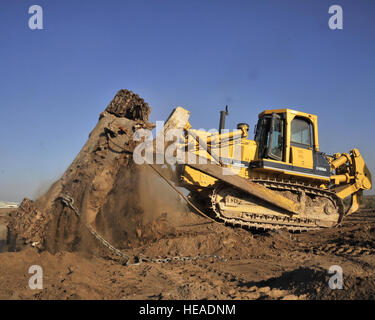 11/05/2008 - SATHER AIR BASE, de l'Iraq - Un aviateurs du 447e Escadron de génie civil expéditionnaire utilise un bulldozer jusqu'à ce qu'un vieux peuple irakien char de combat principal T-72 qui a été retrouvé enterré près de la piste à l'aéroport international de Bagdad. Le réservoir a été un obstacle à la sécurité des opérations de l'aérodrome et a dû être enlevé. Le sergent-chef. Brian Davidson) Banque D'Images