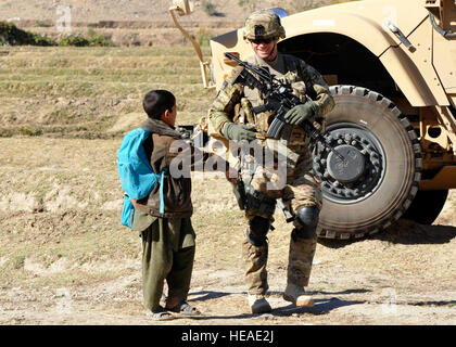 Le capitaine de l'armée américaine Garrett Gingrich (droite) de Waterloo, Iowa, commandant de la Compagnie Charlie, 1er Bataillon, 133e Régiment d'infanterie, parle d'un enfant afghan lors d'une patrouille dans le district de Alingar de base ici le 10 novembre. Les commandos étaient enquête sur un incident dans le district où des éléments anti-gouvernementaux ont brûlé des fournitures, y compris plus de 400 exemplaires du Coran, à une école pour filles dans le district. Les Commandos fonctionnent à partir d'une base d'opérations avancée dans Kalagush Province Nuristan. Le chef de l'US Air Force Master Sgt. Richard Simonsen, Équipe provinciale de reconstruction Nuristan Affaires publiques) Banque D'Images