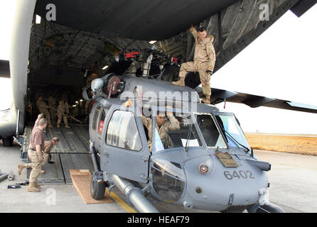 BASE AÉRIENNE DE MANAS, au Kirghizistan -- porteurs aériens déployés dans la 376e escadre expéditionnaire aérienne ici travailler avec les mainteneurs de chargement d'un Blackhawk UH-60L'hélicoptère de sauvetage dans un C-17 l'arrimeur dirigée à l'Afghanistan à l'appui de l'opération Enduring Freedom. Les responsables et les hélicoptères sont déployés à partir du 33e Escadron de sauvetage, Zwevegem Air Base, le Japon. Banque D'Images