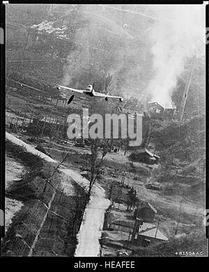 Photos de la guerre de Corée - Un F-80 laissant tomber des bombes au napalm à Suan Cette photo d'une U.S. Air Force F-80 Shooting Star Le chasseur-bombardier a retenu l'action qui a eu lieu le 8 mai lors de la journée de vols de cinquième, l'aviation de l'Armée de l'air soufflé le Parti communiste deux-mille carré centre d'approvisionnement à Suan dans la plus grande grève de l'air de la guerre de Corée. La zone de stockage, 35 miles au sud-est de Pyongyang, a été tuée avec plus de 12 000 gallons de napalm larguées par les avions de l'attaque. Sur cette photo, un réservoir de napalm peut être vu juste après avoir été libéré. Il est au-dessous de l'aile gauche du jet. Target Banque D'Images