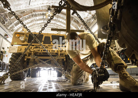 Le s.. Ryan Vanterpool mondiales vers le bas une mine-résistant, armored-véhicule de protection, connu comme un MRAP, sur un C-17A Globemaster III le 2 octobre 2013, à l'aérodrome de Bagram, en Afghanistan. Bagram est devenue une importante plaque tournante pour les opérations en arrière hors de l'Afghanistan. Le 455 e Escadron expéditionnaire Port Aérien section spéciale de détention poussé 4,2 millions de livres de matériel en arrière pendant le mois de septembre. Vanterpool, Honolulu, Hawaii, est déployée à partir de Joint Base McGuire-Dix-Lakehurst, New Jersey. Vanterpool est une antenne PAE 455 e porter. Le sergent-chef. Ben Bloker) Banque D'Images