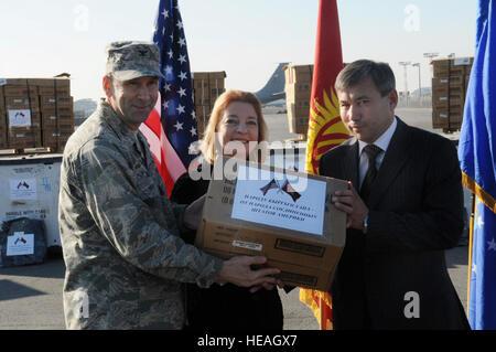 Le colonel Christopher Bence, 376e escadre expéditionnaire aérienne commandant et Tatiana Gfeoller, Ambassadeur des États-Unis à la République kirghize, la première case de la main Meals-Ready-à-manger d'akyl Aitbaev, Vice-Ministre des situations d'urgence, l'assistance humanitaire au cours d'une cérémonie, le 25 novembre. Le ministère américain de la Défense a donné plus de 31 000 mètres et plus de 100 sacs de couchage par temps froid, évaluée à 250 000 $, pour aider les sections locales qui peuvent avoir besoin de l'aide au cours de l'hiver prochain. Banque D'Images