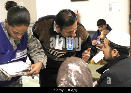 Le Dr Abdul Rasheed afghane et de la Force aérienne Aviateur Senior Katrevious Swift parle avec un survivant d'avalanche à l'hôpital Théâtre conjoint Craig sur l'aérodrome de Bagram, en Afghanistan, le 9 février 2010. Des dizaines d'Afghans ont été prises à Bagram Airfield après les avalanches a frappé un col de montagne dans la province de Parwan. Tech. Le Sgt. Jeromy K. Cross) Banque D'Images