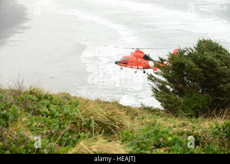 Un équipage à bord d'un hélicoptère MH-65 Dolphin survole Benson plage près de la North Head Light dans Fez, Wash., lors d'un vol d'entraînement, le 10 novembre 2016. L'équipage prend part à une session de l'école de sauvetage hélicoptère avancé mené par l'équipe responsable de la normalisation de l'aviation de la Garde côtière canadienne Centre de Formation à Mobile (Alabama). U.S. Coast Guard Maître de 1re classe Levi Lire. Banque D'Images