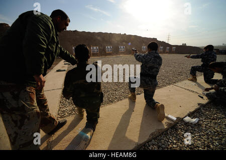 L'Adjudant de police irakienne Ahmed indique les élèves sur la façon de tirer un pistolet dans la position à genoux lors d'un tir au pistolet class à l'Académie de la fonction publique de Mossoul à Mossoul, Irak, janv. 19. Banque D'Images