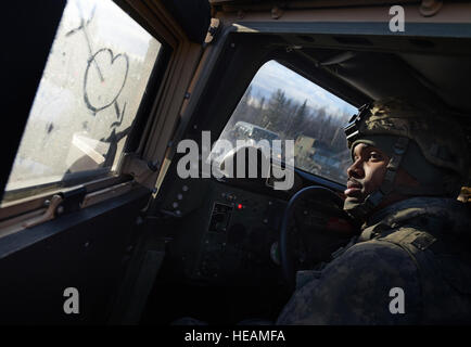 La CPS. Christopher Lee, originaire de Saint Louis, affecté à l'armée américaine Alaska's 109e compagnie de transport, ferme sa porte de son HMMWV, Jeudi, Novembre 13, 2014, sur une base commune Elmendorf-Richardson, Alaska, au cours d'un convoi exercice de tir réel. Les soldats ont également exécuté simultanément réagir à des procédures d'embuscade avec suivi et hâtives sur des opérations de récupération du véhicule délibérée. Justin Connaher) Banque D'Images