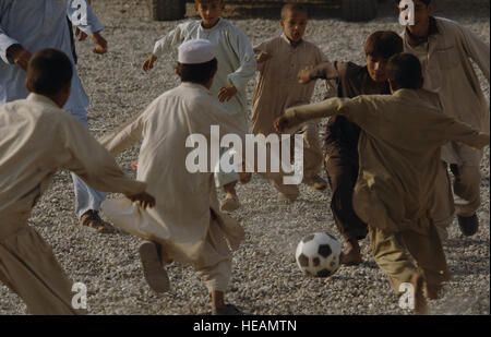 L'armée et la Force aérienne Des membres de l'Équipe de reconstruction provinciale de Nangarhar, et les enfants de la communauté locale jouent au football ensemble à l'EPR, base d'opérations avancée de Jalalabad, 9 novembre 2007. L'EPR est de Nangarhar une équipe conjointe d'aviateurs, soldats, et des représentants du Département américain d'État, l'Agence américaine pour le développement international et le ministère de l'Agriculture des États-Unis. L'équipe est responsable d'aider le gouvernement de la République islamique d'Afghanistan d'améliorer la sécurité, la gouvernance et la promotion de la reconstruction dans la province de Nangarhar. L'équipe évalue les besoins de la communauté et e Banque D'Images