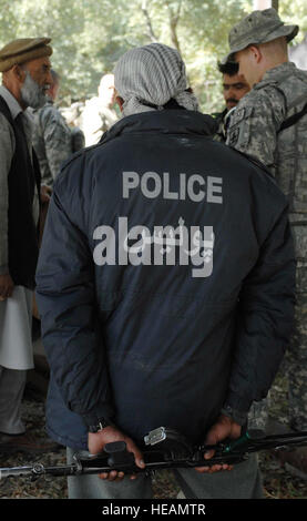 071106-F-0451J-015 - la province de Nangarhar, Afghanistan - Un agent de la police nationale afghane est à l'écoute de la conversation entre travailleurs afghans metal et de Nangarhar membres de l'Équipe provinciale de reconstruction au cours d'une évaluation d'un groupe de métal local shop, le 6 novembre. L'EPR est de Nangarhar une équipe mixte d'aviateur, soldats, et des représentants du Département américain d'État, l'Agence américaine pour le développement international et le ministère de l'Agriculture des États-Unis. L'équipe est responsable d'aider le Gouvernement de la République islamique d'Afghanistan d'améliorer la sécurité, de la gouvernance et de promouvoir le développement en N Banque D'Images