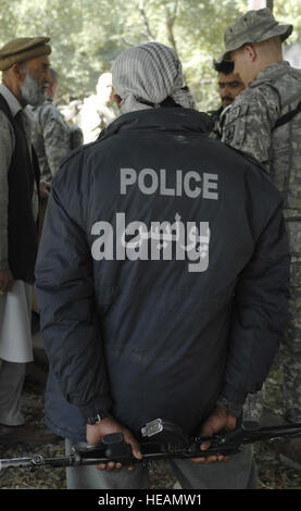 La province de Nangarhar, Afghanistan - Un agent de la police nationale afghane est à l'écoute de la conversation entre travailleurs afghans metal et de Nangarhar membres de l'Équipe provinciale de reconstruction au cours d'une évaluation d'un groupe de métal local shop, 6 novembre 2007. L'EPR est de Nangarhar une équipe mixte d'aviateur, soldats, et des représentants du Département américain d'État, l'Agence américaine pour le développement international et le ministère de l'Agriculture des États-Unis. L'équipe est responsable d'aider le Gouvernement de la République islamique d'Afghanistan d'améliorer la sécurité, de la gouvernance et de favoriser la reconstruction à Nangarhar Pr Banque D'Images