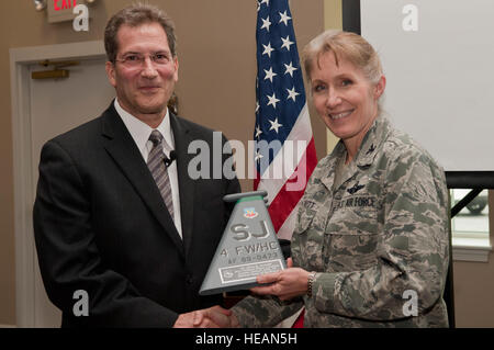 Le Dr Glenn Schiraldi, Université du Maryland School of Public Health, professeur de psychologie et orateur invité, à gauche, est présenté le cas d'une plaque par le colonel Jeannie Leavitt, commandant de la 4e Escadre de chasse, au cours du déjeuner de prière, le 2 mai 2014, à Seymour Johnson Air Force Base, N.C. Schiraldi a parlé aux membres de l'équipe de résistance spirituelle à propos de Seymour. Navigant de première classe Shawna L. Keyes) Banque D'Images