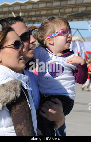 La Nellis Air Force Base, NEVADA -- Miranda Barnes, SSgt Eaux Andrew et sa fille, regarder les eaux Andria F-22 demo au cours de l'Aviation 2010 Nellis Nation Open House le 13 novembre. La Nellis Portes ouvertes est l'occasion pour la communauté de Las Vegas pour voir des démonstrations aériennes et des expositions statiques de différents avions de l'armée. La journée portes ouvertes constitue également le dernier air show de l'année pour l'US Air Force Thunderbirds de l'Escadron de démonstration aérienne. Un membre de la 1re classe Daniel Hughes Banque D'Images