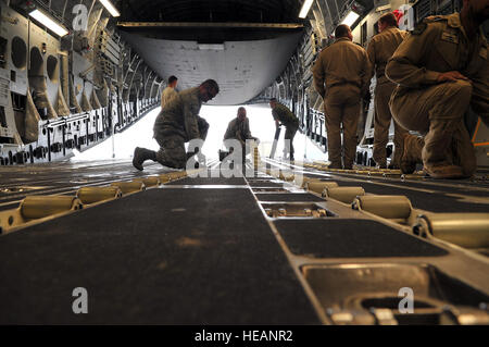 Le sergent de l'US Air Force. Josh Foley, 36e Escadron d'intervention la mobilité port aérien superviseur, guides un membre des Forces canadiennes de leur équipement de déchargement C-17 Globemaster III 9 mai, à l'aéroport international de Tribhuvan à Katmandou, au Népal. L'Armée népalaise et les aviateurs ont travaillé ensemble pour traiter 537 816 livres de marchandises dans un délai de 24 heures à partir de 13 aéronefs fournissant des secours après un séisme de magnitude 7,8 a frappé le pays le 25 avril. Le s.. Melissa B. White Banque D'Images