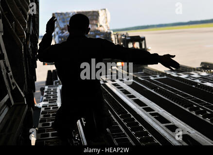 Tech. Le Sgt. Eric Blevins, 316e Escadron de transport aérien l'arrimeur, marshals un chargeur de fret vers un C-17 Globemaster, 27 mai 2015 à Hurlburt Field, en Floride, les membres de la 823e RED HORSE déployés au Honduras à l'appui de Nouveaux Horizons 2015, un événement annuel visant à former des ingénieurs civils militaires et les professionnels à déployer et à mener des opérations conjointes. Navigant de première classe Ryan Conroy Banque D'Images