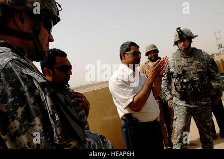 (L à R) Le lieutenant-colonel de l'ARMÉE AMÉRICAINE Michael J. Fadden, commandant du 1er Bataillon, 12e Régiment de cavalerie, son interprète, Saleh Hassan Ali, le maire de l'Qayyarah, District de l'armée américaine et le Capt Marc Austin, commandant du quartier de l'entreprise Banque D'Images