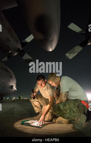 Le s.. Kyle Law et le sergent. Joshua Jorgensen, 774e Escadron de transport aérien expéditionnaire chefs d'équipage, consulter un ordre technique permettant de résoudre un C-130H Hercules problème moteur à Bagram Airfield, la province de Parwan, à l'Afghanistan, le 6 octobre 2013. L'équipage du Hercules 774e EAS livré 32 faisceaux de fret au cours de deux voyages en zones de dépôt à distance dans la province de Ghazni, Afghanistan. La loi, un San Antonio, Texas, indigènes et Jorgensen, Brentwood, en Californie, les autochtones sont déployés à partir de la Base aérienne de Little Rock, Ark. (Photo USAF/Master Sgt. Ben Bloker) Banque D'Images