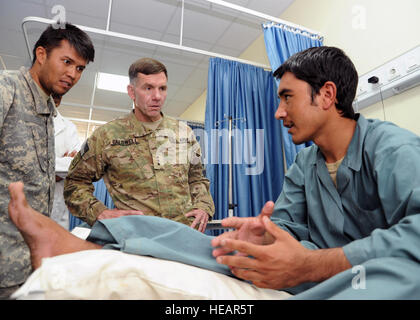 Le Lieutenant-général William B. Caldwell, IV, Mission de formation de l'OTAN Afghanistan Commandant, Centre, parle avec un soldat de l'Armée nationale afghane à l'hôpital de l'ANA dans la province d'Herat, Afghanistan, le 18 août 2011. Le soldat blessé la jambe lorsque le véhicule dans lequel il prenait place a frappé un IED dans la province de Badghis. Le général a visité l'hôpital d'évaluer les progrès et les défis de l'élaboration d'une installation de traitement médical ANA durable et s'est réuni avec les patients pour montrer son soutien pour leur service à leur pays. Banque D'Images