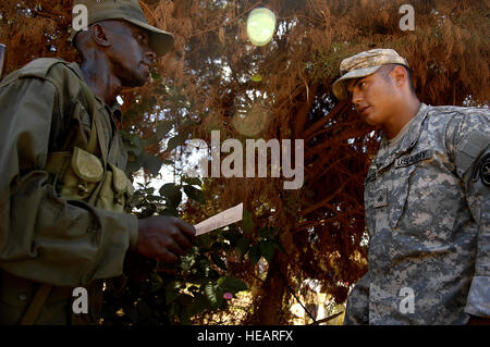 Le Sgt. Max Weinstock avec le 1er Bataillon, 3e Régiment d'infanterie américaine, déployés à partir de Ft. Myer, Va., écoute en tant que membre de l'Uganda People's Defence Force appels d'une ligne 'neuf' rapport lors d'une compétition à l'escouade emplacement avancé d'opérations Kasenyi, l'Ouganda, le 3 avril 2008. Les soldats s'entraînent avec les membres de la vieille garde. La temporisation de la concurrence exige que l'escouade de soldats de l'UPDF à démontrer leur capacité le long d'un 5,4 km fournissant des soins médicaux dans le domaine, traçant cinq caractéristiques du terrain sur une carte, d'appeler un 'neuf' ligne rapport, donnant une S.A.L.U.T.E. rapport, ainsi que complet Banque D'Images