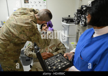 Le sergent de l'US Air Force. Vernon :, un technicien médical affecté à la 455 e Expeditionary Medical Group, les lieux d'un oeil prosthétique dans l'œil gauche d'un soldat afghan alors qu'à l'hôpital Théâtre conjoint Craig Air à Bagram, en Afghanistan, le 7 août 2014. Le soldat a subi un traumatisme oculaire quand les éclats d'une explosion l'a touché à l'œil il y a quatre mois. Le prix est originaire de Goldsboro, N.C. et déployé le formulaire 4e Escadron en médecine aérospatiale à Seymour Johnson Air Force Base, N.C. Le sergent-chef. Cohen A. Young Banque D'Images