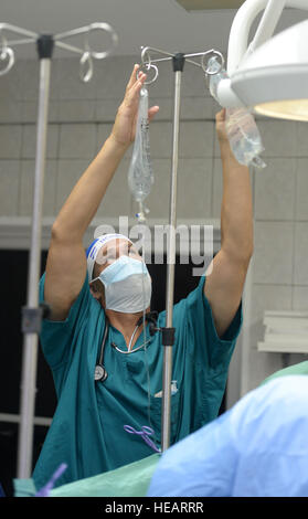 U.S. Air Force Le major Frederick Grois, 779ème escadron d'opérations médicales anesthésiste, hors de Joint Base Andrews, Md., remplace les sacs de liquide intraveineux pour un patient subissant une chirurgie de la vésicule biliaire dans la salle d'opération de l'Hôpital Dr. Salvador Paredes à Trujillo, le Honduras, le 2 juillet 2015. Les sacs aident à prévenir la déshydratation durant la chirurgie. Grois est une partie d'un certain nombre de médecins de l'US Air Force au Honduras dans le cadre du programme Nouveaux Horizons Honduras 2015 Exercice d'entraînement. De nouveaux horizons a été lancé dans les années 80 et est un rapport conjoint sur l'exercice d'assistance humanitaire que U.S. Southern Command cond Banque D'Images