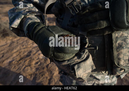 Un soldat de la Compagnie Alpha, 1er bataillon blindé, 77e Régiment blindé 3ème Armored Brigade Combat Team, 1re Division blindée, à l'Est de la Force de réaction de l'Afrique (EARF) Charge de munitions supplémentaires dans une pochette sur son gilet pendant un exercice de tir réel à l'ensemble de la formation d'Arta à Djibouti, le 30 mai 2015. L'EARF est une force de réaction rapide destinée à défendre les actifs des États-Unis au sein de la Force opérationnelle interarmées combinée de la Corne de l'Afrique zone de responsabilité. ( Le s.. Gregory Brook/ libéré) Banque D'Images