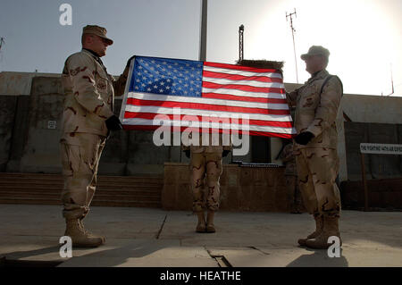 Bagdad, Irak -- Personnel des sergents. Andrew Keller et Jody Nitz et exécuter une Kolnsberg Shannon le lever du drapeau officiel de la cérémonie et le pliage du drapeau des États-Unis à Bagdad, en Irak. La Sather Air Base sur la garde d'honneur soulevées et plié 23 drapeaux des États-Unis. Les sergents Keller et Nitz et Kolnsberg importants sont affectés à la 447e Escadron médical expéditionnaire. Tech. Le Sgt. Cecilio M. Ricardo Jr.) (sortie) Banque D'Images