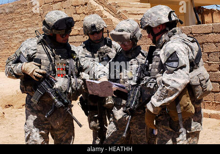 Le capitaine de l'armée américaine Todd Vandine, commandant de la Compagnie Bravo, 2e Bataillon, 7e régiment de cavalerie, 4e Brigade Combat Team, 1re Division de cavalerie, à Fort Bliss, au Texas, donne sur une carte de terrain avec 1Lt Adam Gochenour, SGT Jacob Edwards et SFC Rod Wionowsky, 431ème bataillon d'affaires civiles, dans le désert Al Jazirah village de Khubayrat, environ 30 kilomètres à l'ouest de Mossoul en Irak, le 25 avril 2007. Les soldats se sont rendus dans plusieurs villages de la région désertique de se renseigner sur les conditions de vie et l'état des fournitures scolaires dans la région. ( Le s.. Vanessa Valentine) (Sortie) Banque D'Images