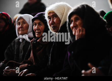 Les femmes kirghizes attendent patiemment leur tour pour recevoir un manteau d'hiver Le 16 janvier 2012, pendant une opération de distribution de chaud et sec dans le Emgekchil Sary-Oi au gymnase de l'école, au Kirghizistan. Plus de 50 aviateurs de la 376e escadre expéditionnaire aérienne Le Centre de Transit de Manas ont donné de leur temps pour aider à la répartition de la région d'Issyk-Koul du Kirghizistan. Banque D'Images