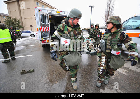 499 Airport Road, Senior Airman Doran gauche, 51e Escadron en médecine aérospatiale technicien en santé publique, et le capitaine Lee Eunlim, 51e Escadron dentaire dentiste général, aident à faire une simulation d'un patient à une ambulance lors d'un scénario de pertes massives d'une opération de l'exercice de préparation, Beverly Bulldog 13-02 à Osan Air Base, la Corée du Sud, le 12 février 2013. Ces scénarios comme aviateurs donner une occasion de perfectionner les compétences de guerre dans un coffre-fort et structuré en préparation pour des éventualités. Le s.. Sara Csurilla) Banque D'Images